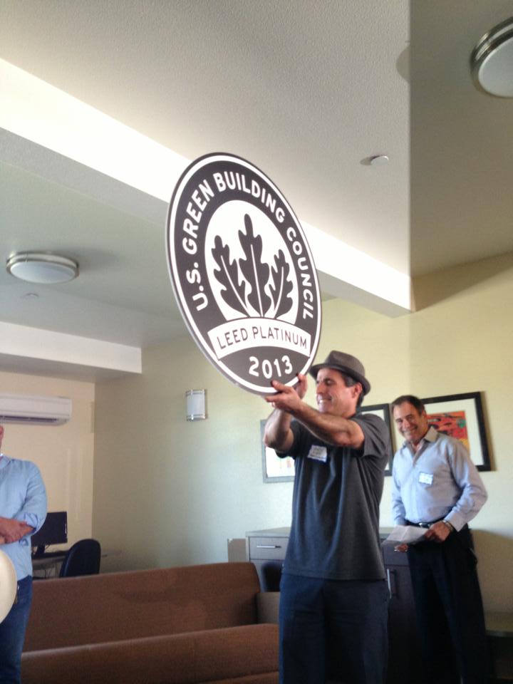 South County Housing’s Director of Housing Development Andy Lief proudly shows off Gilroy Sobrato Apartments’ LEED Platinum plaque. (Photo courtesy South County Housing)