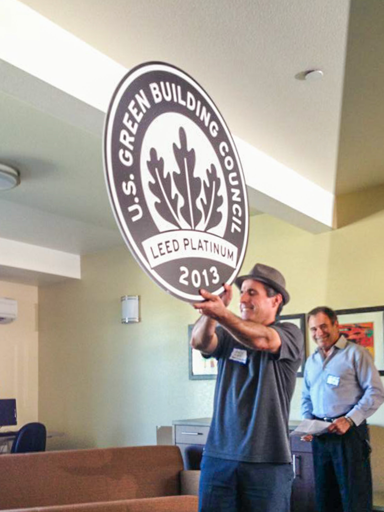 South County Housing’s Director of Housing Development Andy Lief proudly shows off Gilroy Sobrato Apartments’ LEED Platinum plaque. (Photo courtesy South County Housing)