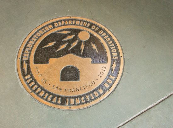Marker for the Exploratorium Department of Operations’ electrical junction box shown in the concrete floor which houses a radiant heating and cooling system. (Photo by Mignon O’Young)