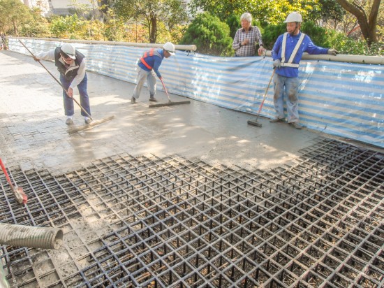Construction of the pedestrian walkway in New Taipei City, Taiwan: the concrete pour takes place after all the Aqueduct Assembly structural grid units and gravel are laid in place. (Photo courtesy Ping Tai Co., Ltd.)